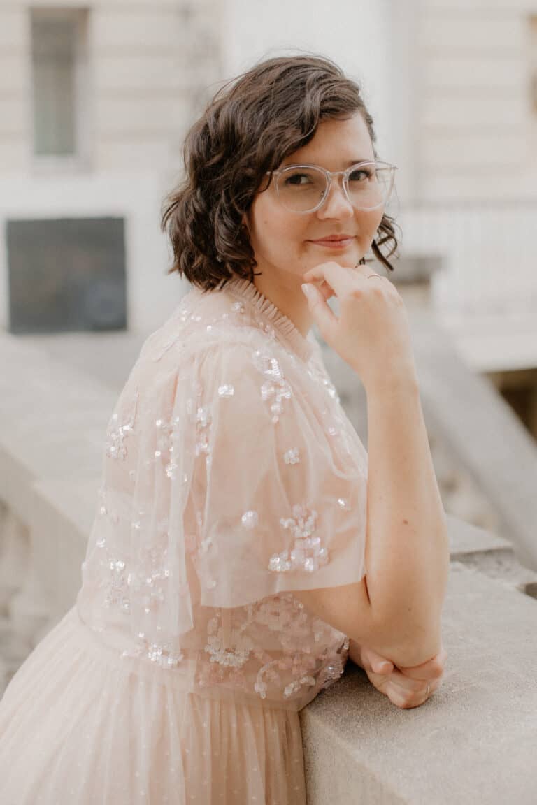 Brünette Frau schaut in die Kamera und trägt ein rosa Kleid